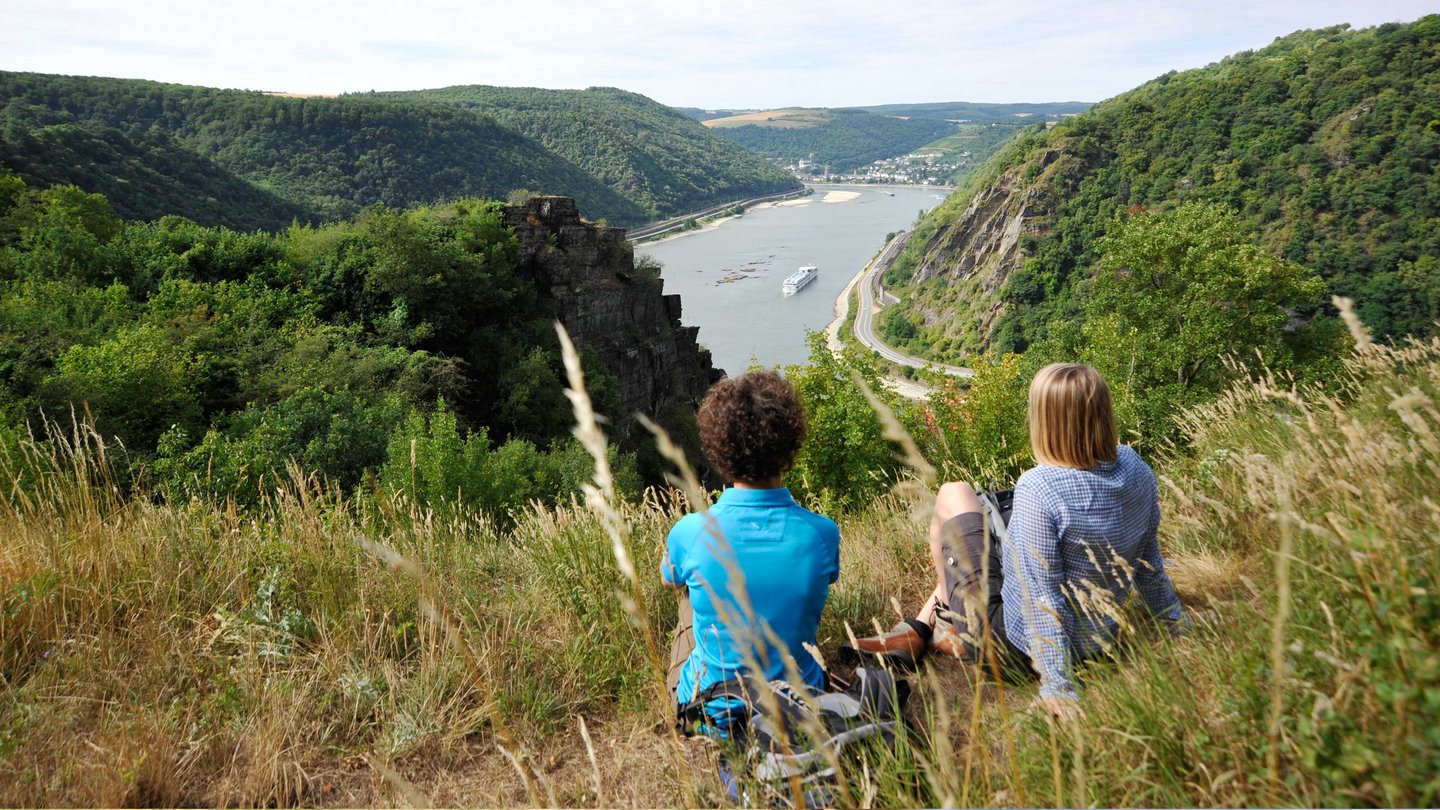 Zwei Wandererinnen machen Rast mit Blick auf den Rhein