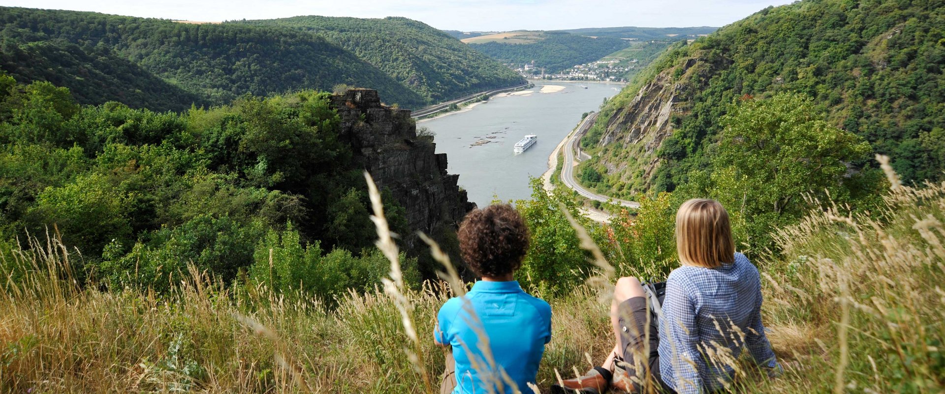 Zwei Wandererinnen machen Rast mit Blick auf den Rhein