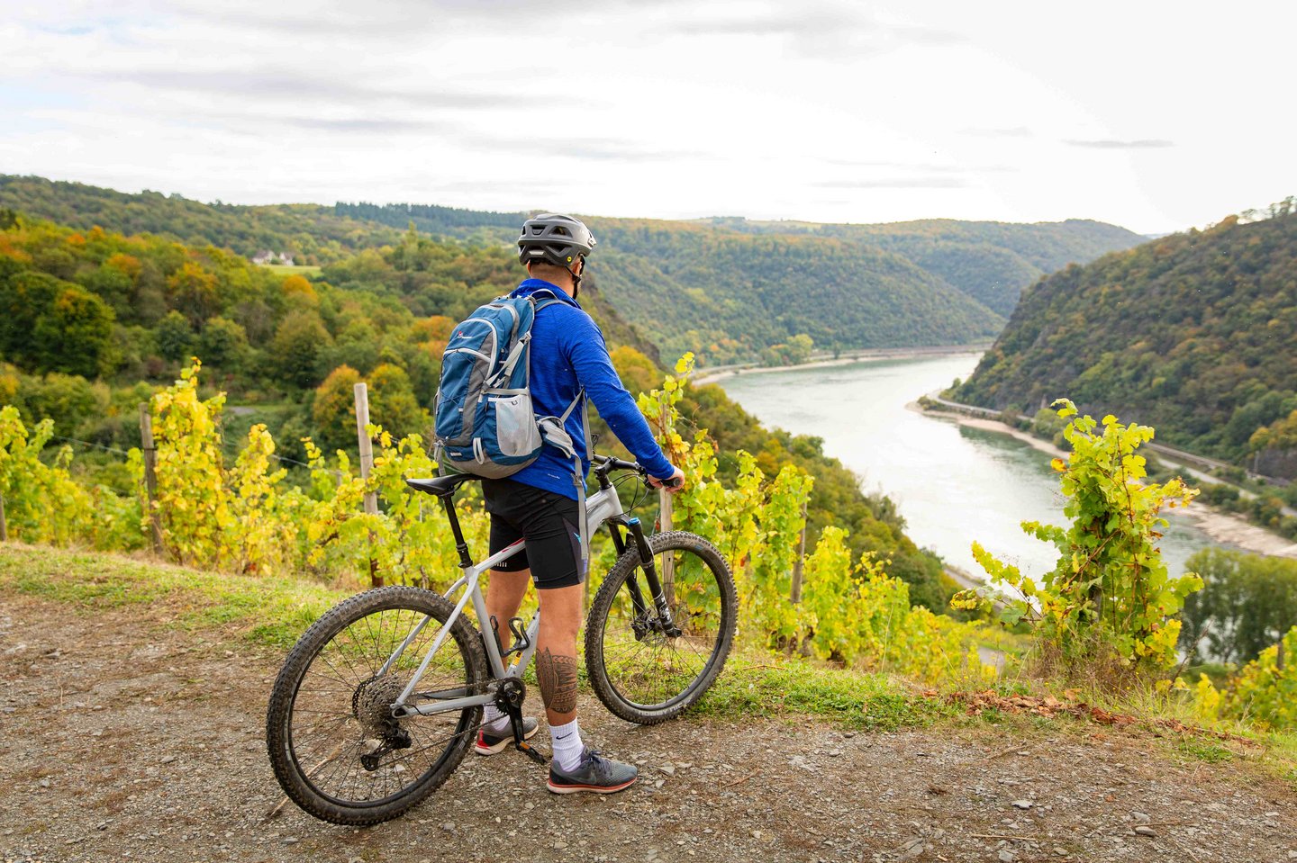 Ein Mann steht mit seinem Mountainbike auf dem Loreley-Felsen