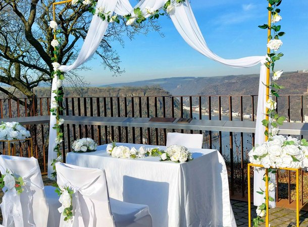 Stühle für eine Hochzeit auf dem Loreley-Plateau, im Hintergrund sieht man Burgen und den Rhein