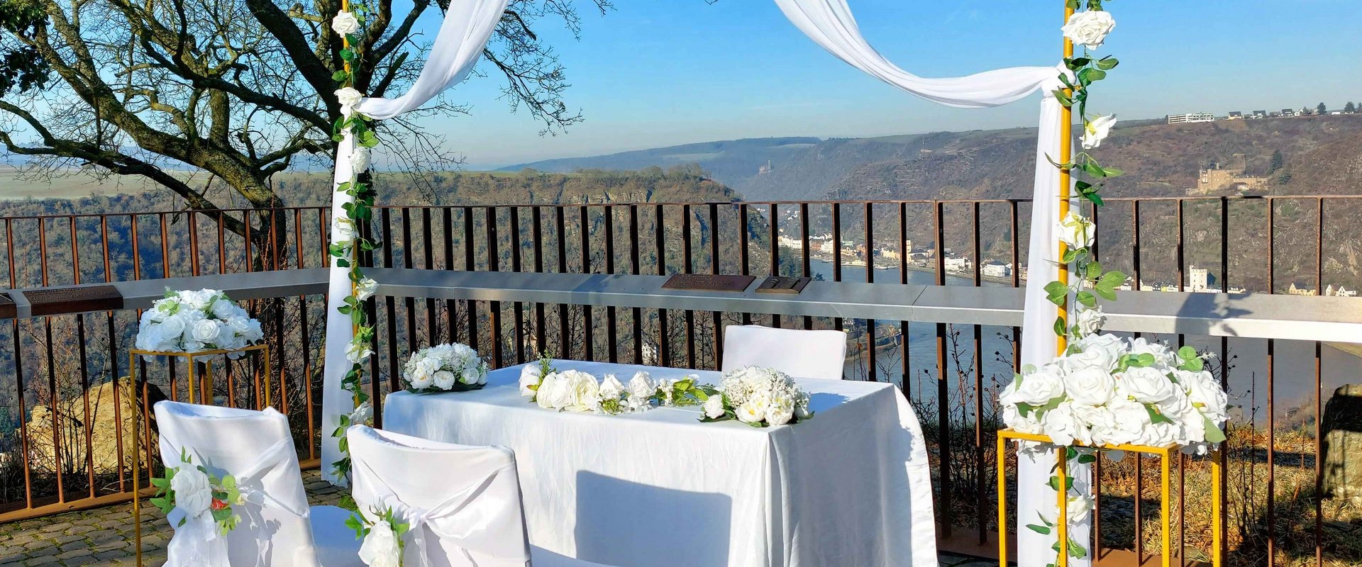 Stühle für eine Hochzeit auf dem Loreley-Plateau, im Hintergrund sieht man Burgen und den Rhein